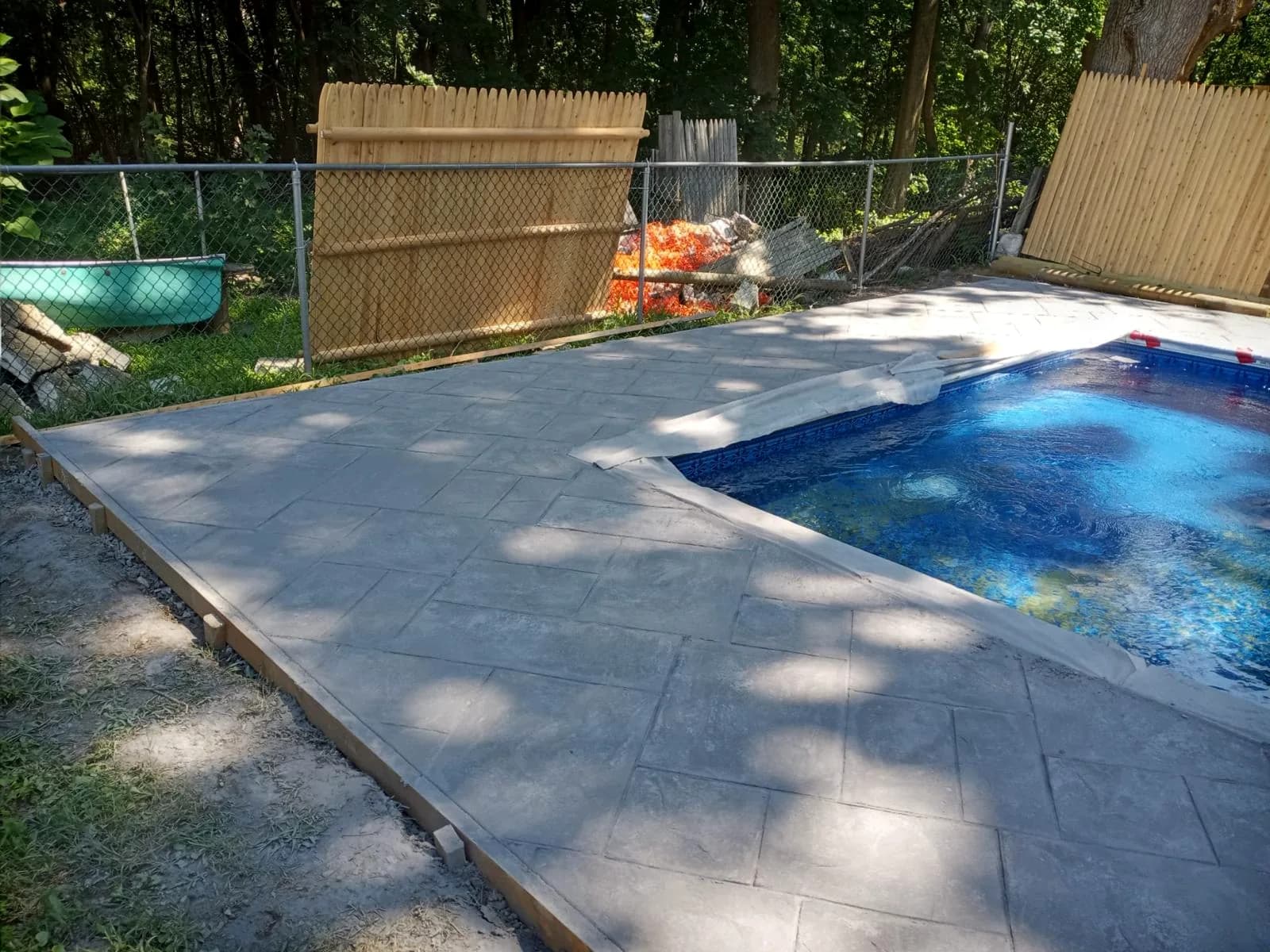 After: new stamped concrete pool deck poured by WR Concrete around the same pool